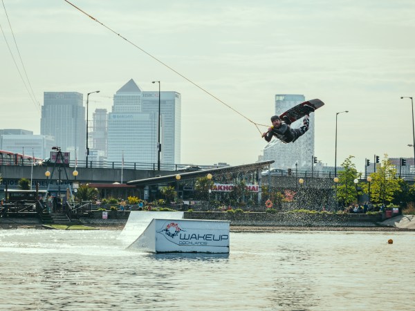 Person wakeboarding in a cityscape with tall buildings in the background.